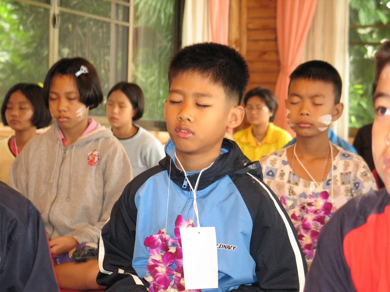 Two young children making a wooden tipi style camp